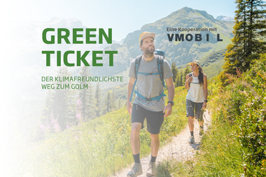 Golmerbahn Green Ticket for Erlebnisberg Golm | © Golm Silvretta Lünersee Tourismus GmbH Bregenz Two hikers in the Golm hiking area with a view of the mountain landscape. The slogan 'Green Ticket - the most climate-friendly way to Golm' is displayed | © Golm Silvretta Lünersee Tourismus GmbH Bregenz