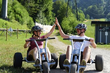 Zwei Personen die sich ein High Five geben am Ende einer Mountaincart Strecke | © Golm Silvretta Lünersee Tourismus GmbH