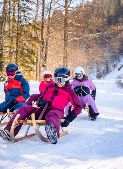 Vier Freundinnen, die gemeinsam die Rodelbahn am Erlebnisberg Golm hinunterrodeln | © Golm Silvretta Lünersee Tourismus GmbH Bregenz, Stefan Kothner